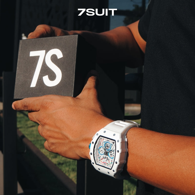 Relógio masculino 7SUIT Orono com caixa branca, detalhes em azul, pulseira ajustável e mostrador esportivo. Sofisticação à prova d’água para homens com personalidade marcante.